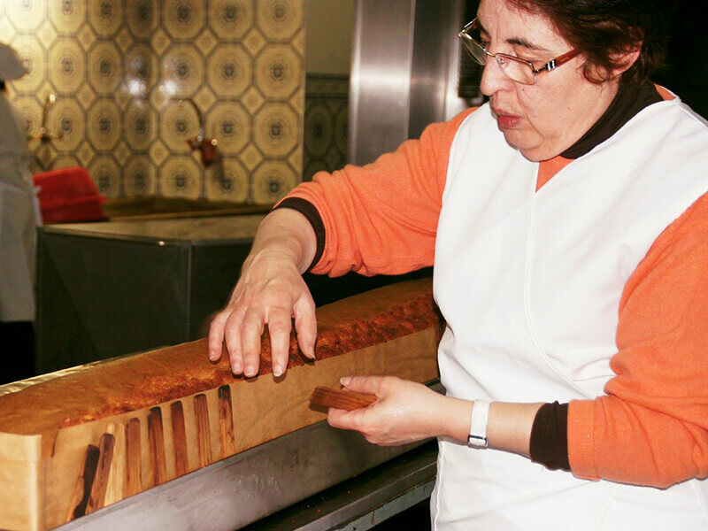 中北部アロウカの大きな長方形のパォンデローを切る準備をするドーセイラ（菓子を作る女性）